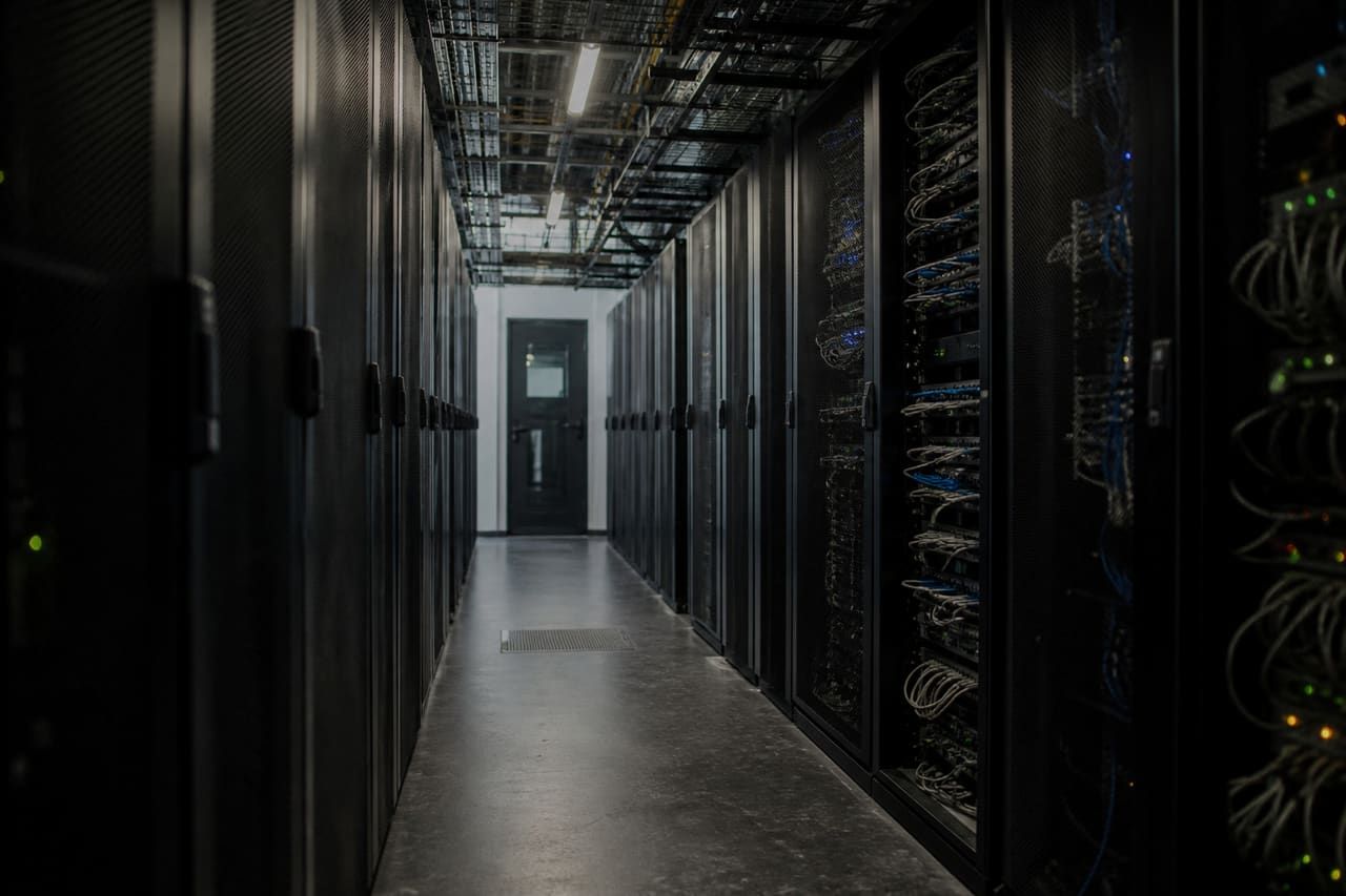 Cold aisle between racks of network and server equipment in a data centre