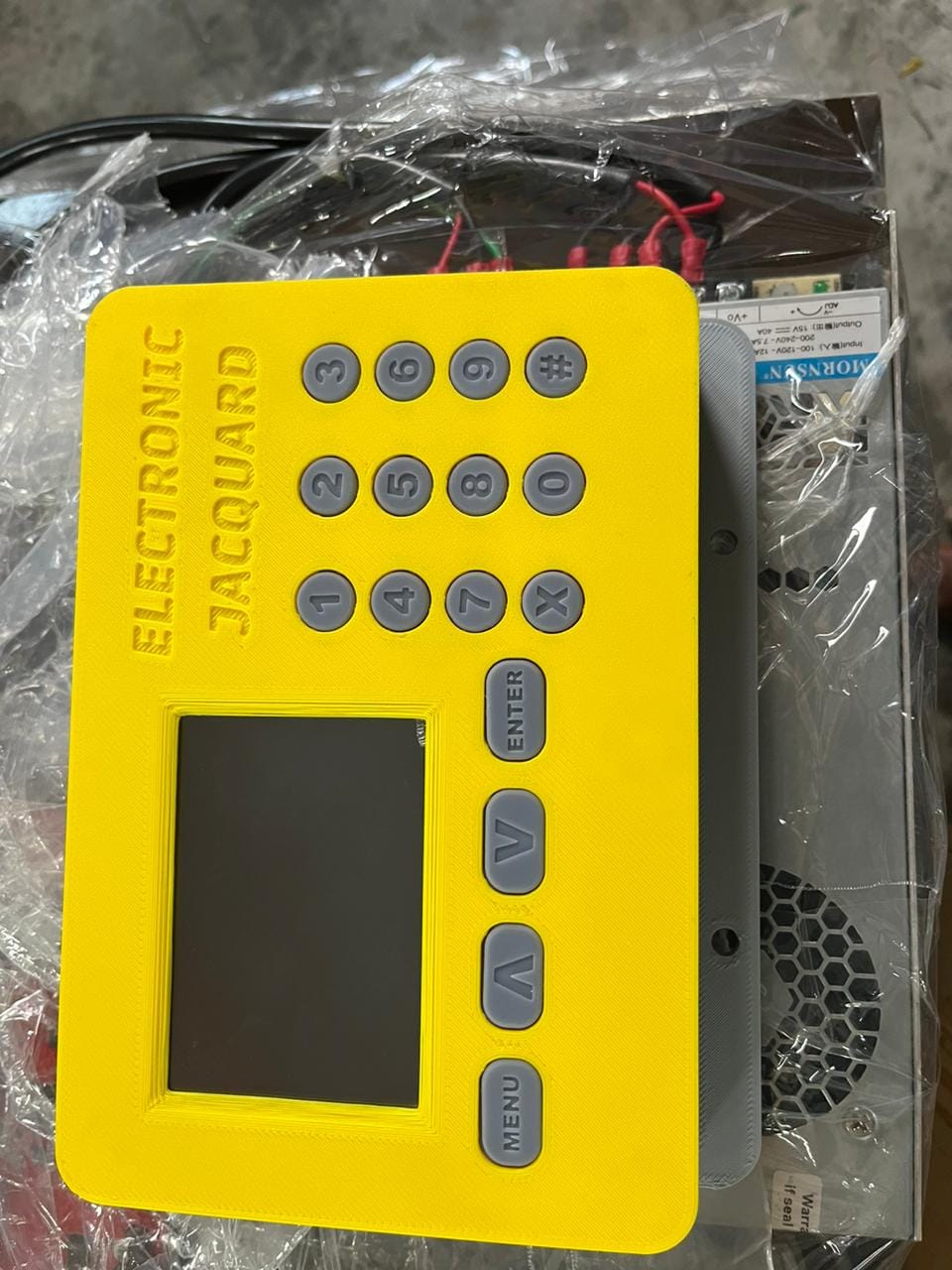 3D printed yellow prototype enclosure for the electronic jacquard controller with keypad and display cutout